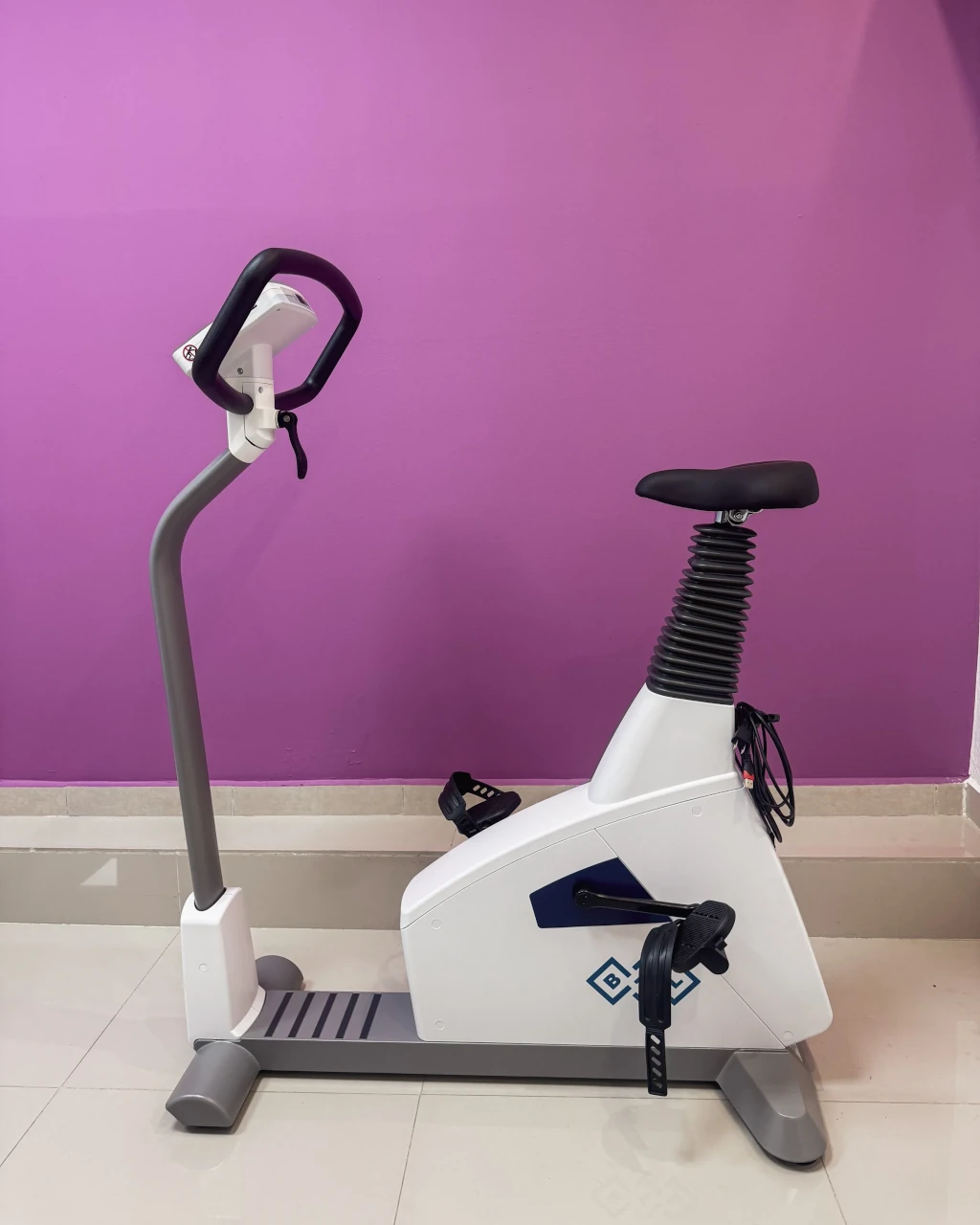 Prueba de esfuerzo en bicicleta ergométrica — paciente pedaleando con electrodos ECG y monitoreo de presión arterial continuo en Medimanage Research Tlalpan CDMX